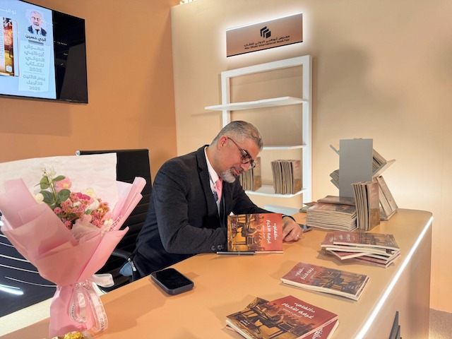 الصحفي آلجي حسين خلال توقيع كتابه "ألغام غرفة الأخبار" في معرض أبوظبي الدولي للكتاب 2025